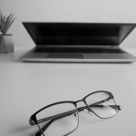 Laptop and eyeglasses on a desk symbolizing better visibility, audience targeting, and advertising strategy for Facebook marketing.