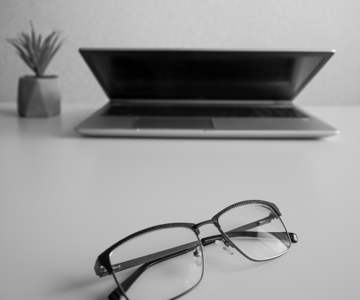 Laptop and eyeglasses on a desk symbolizing better visibility, audience targeting, and advertising strategy for Facebook marketing.