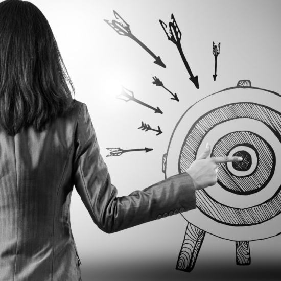 Business owner pointing at a target, representing the importance of having a clear social media strategy and creating marketing that connects with the right audience.