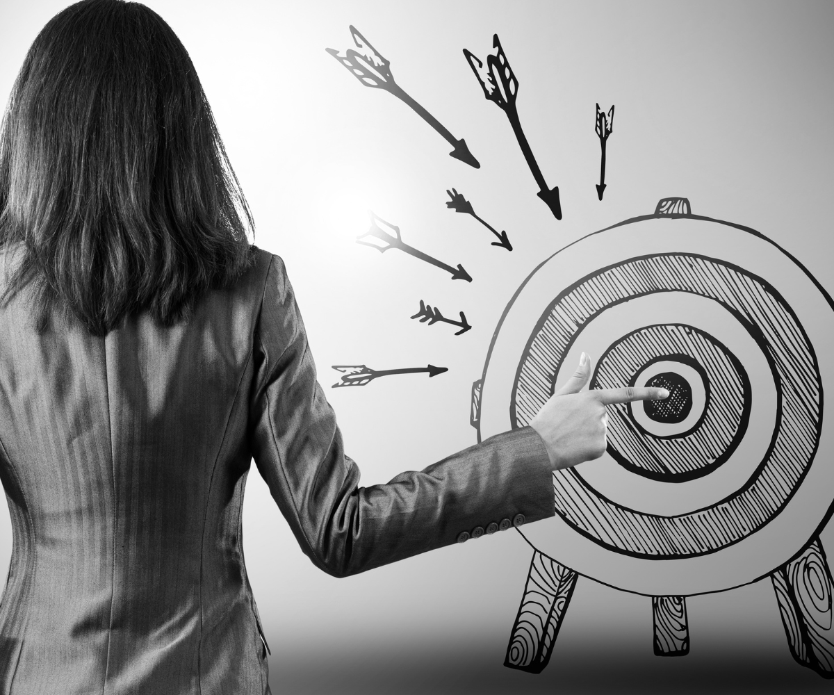 Business owner pointing at a target, representing the importance of having a clear social media strategy and creating marketing that connects with the right audience.